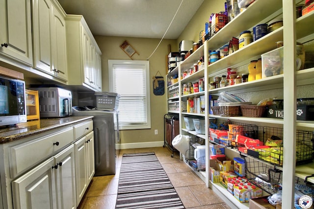 220 Quail Trl, Texarkana, TX 75501 - interior space with separate washer and dryer, light tile patterned flooring, cabinet space, and baseboards