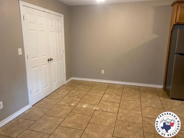 2415-2417 Laurel, Texarkana, AR 71854 - unfurnished bedroom with freestanding refrigerator, baseboards, light tile patterned floors, and a closet
