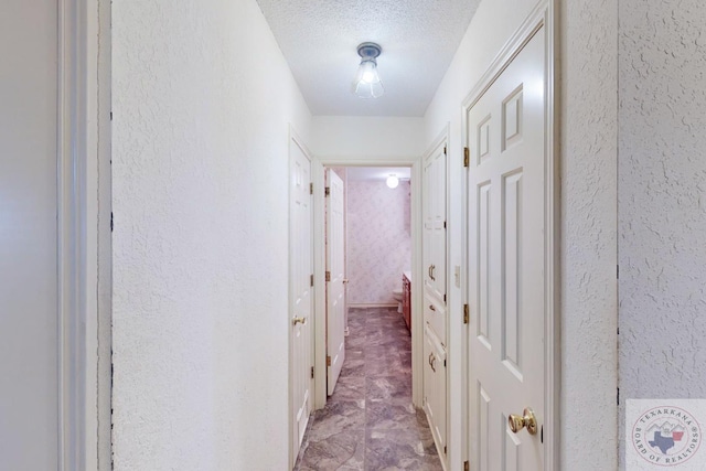 hall with a textured ceiling