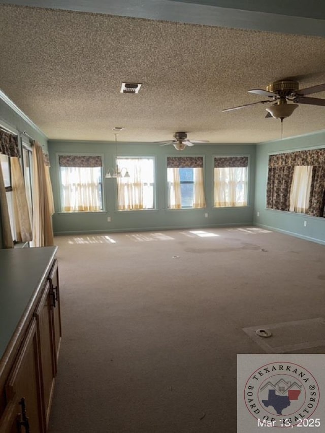 unfurnished living room with visible vents, carpet floors, and a textured ceiling