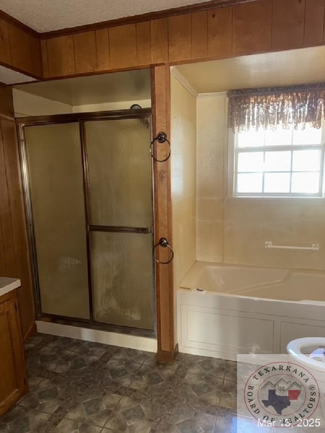 bathroom featuring a shower with door, a bathing tub, and a textured ceiling