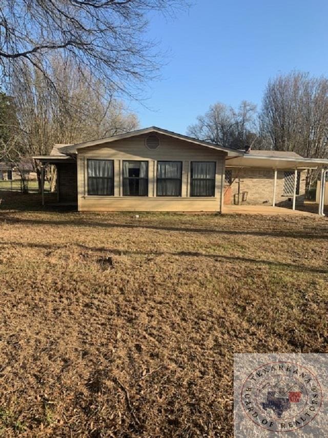 view of front of house with a carport and a front lawn