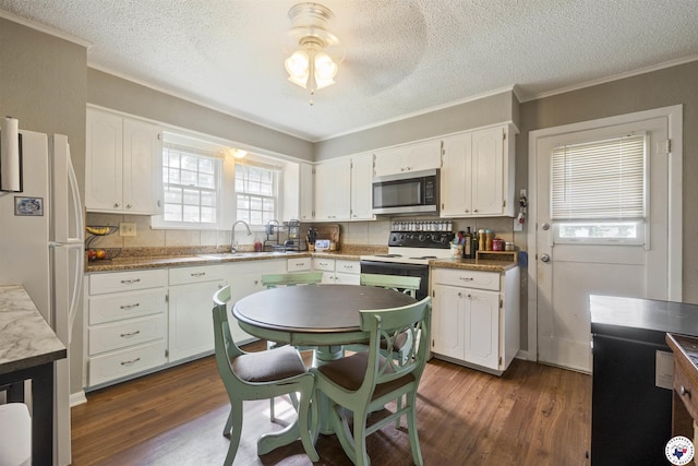 1324 Linden Ave, Texarkana, AR 71854 - kitchen with stainless steel microwave, dark wood-style floors, a textured ceiling, white cabinetry, and range with electric stovetop