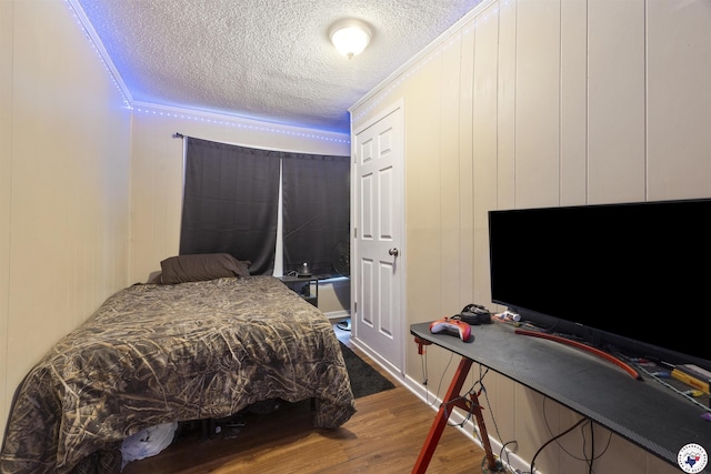 1324 Linden Ave, Texarkana, AR 71854 - bedroom with dark wood-type flooring, a textured ceiling, ornamental molding, and a decorative wall