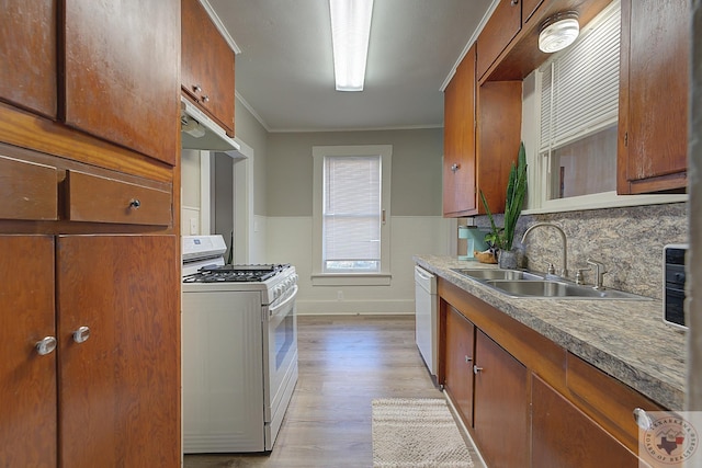 kitchen with sink, white appliances, light wood-type flooring, and crown molding