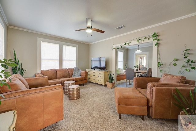 living room featuring a wealth of natural light, crown molding, and carpet flooring