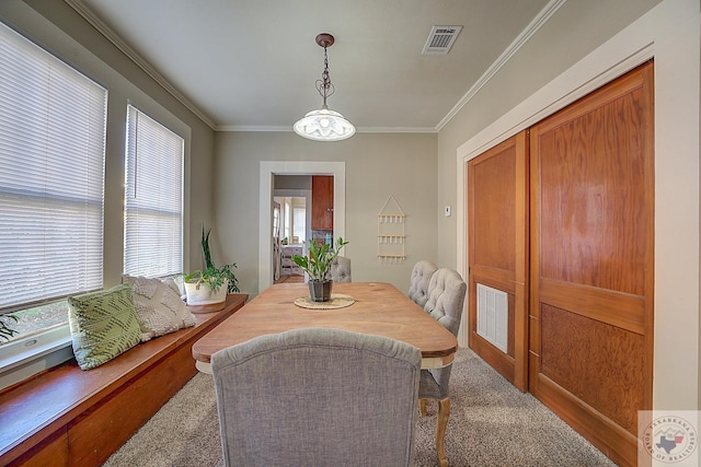 carpeted dining area featuring crown molding and plenty of natural light