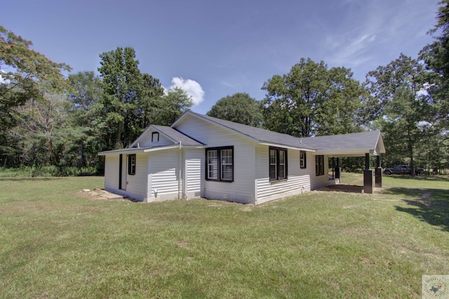 view of front of property with a front lawn and a carport