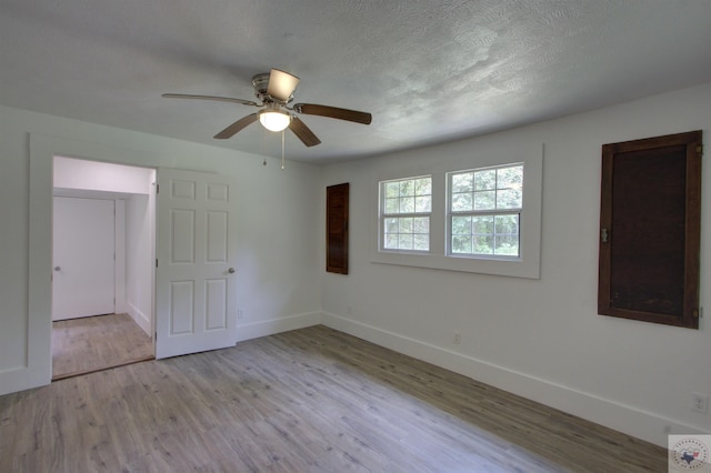 spare room featuring ceiling fan, a textured ceiling, and light hardwood / wood-style flooring