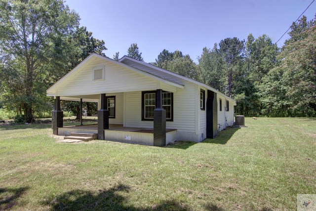 view of front of home featuring a porch, central air condition unit, and a front yard