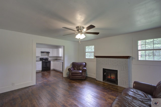 unfurnished living room featuring ceiling fan, a wealth of natural light, dark hardwood / wood-style floors, and a fireplace