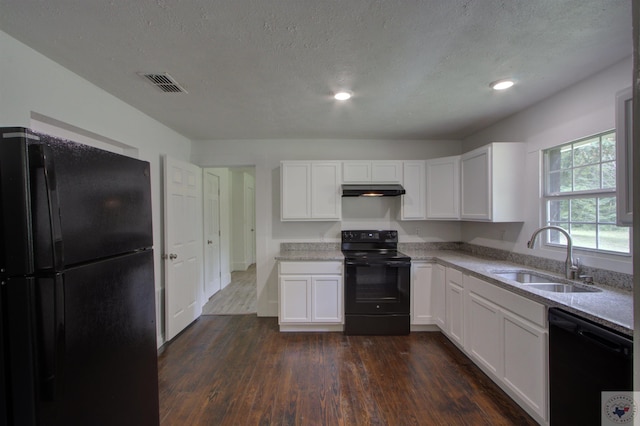 kitchen with a textured ceiling, white cabinets, black appliances, sink, and dark hardwood / wood-style floors