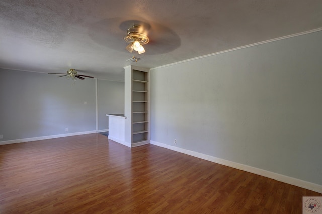 unfurnished living room featuring crown molding, ceiling fan, dark hardwood / wood-style flooring, built in shelves, and a textured ceiling