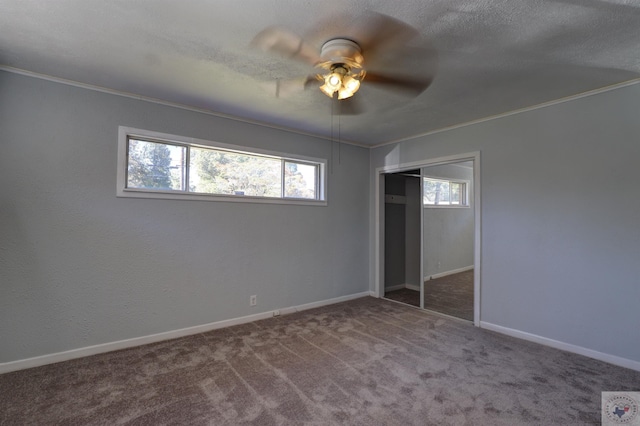 unfurnished bedroom featuring a closet, ceiling fan, carpet floors, and multiple windows