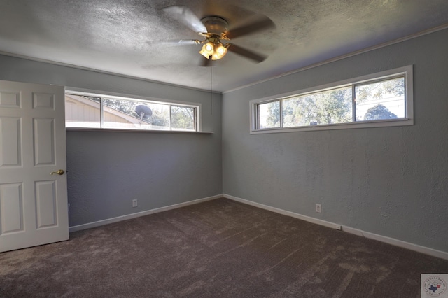 empty room featuring crown molding, ceiling fan, and dark carpet