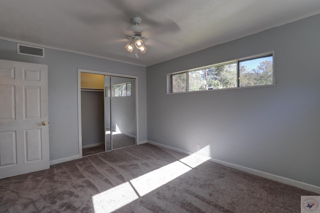 unfurnished bedroom with a closet, ceiling fan, and dark colored carpet