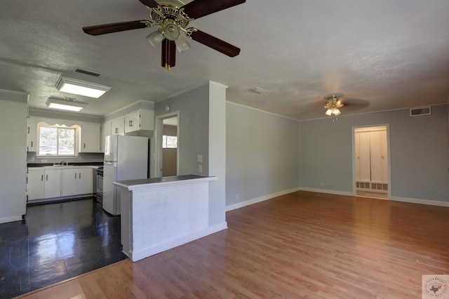 kitchen with ceiling fan, sink, white refrigerator, white cabinetry, and light hardwood / wood-style floors