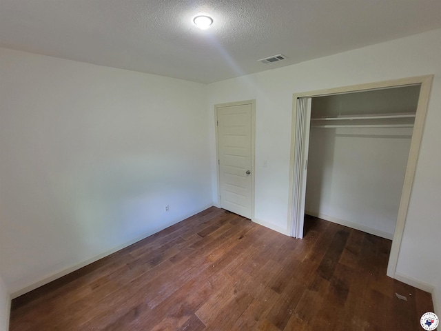 121 Circle Dr, Bogata, TX 75417 - unfurnished bedroom featuring wood finished floors, a closet, and a textured ceiling
