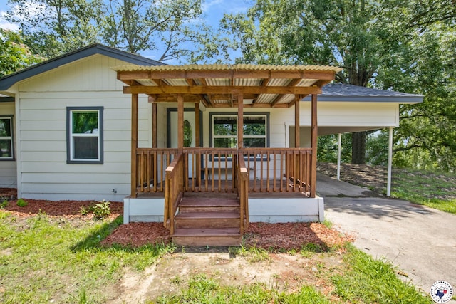 121 Circle Dr, Bogata, TX 75417 - view of front of home with concrete driveway, covered porch, and an attached carport