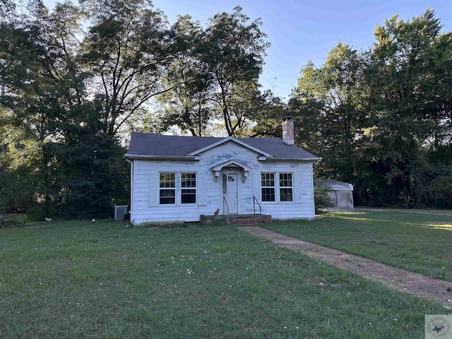 view of front facade with a front lawn and central air condition unit