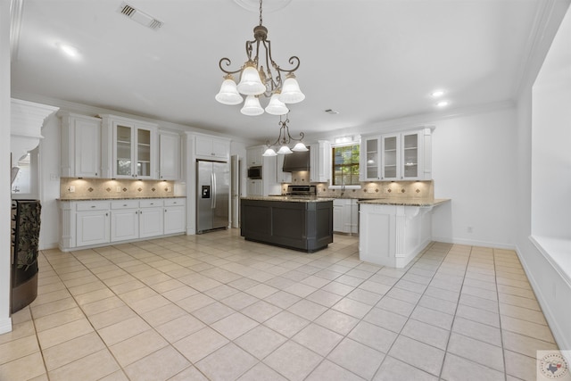 kitchen with tasteful backsplash, white cabinetry, hanging light fixtures, and stainless steel appliances