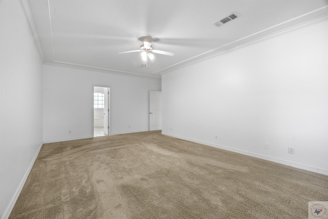 carpeted empty room with baseboards, a ceiling fan, visible vents, and crown molding