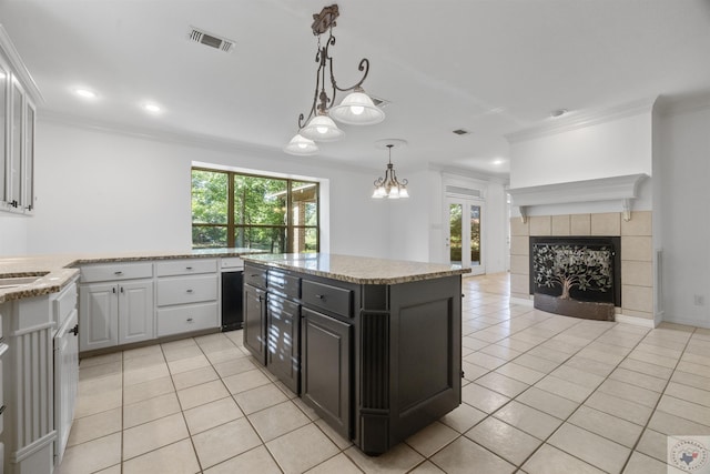 kitchen featuring crown molding, a center island, visible vents, and white cabinets