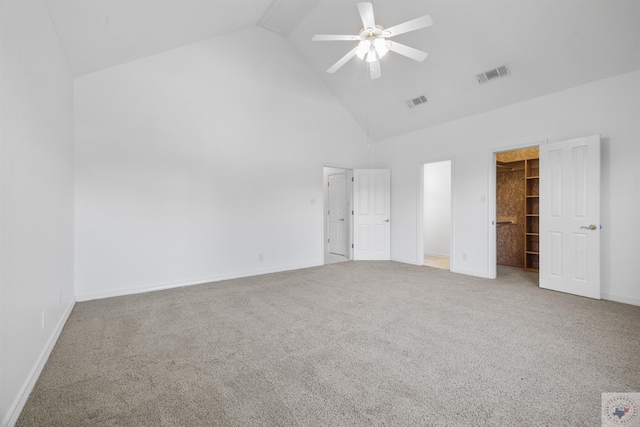 unfurnished bedroom featuring a spacious closet, ceiling fan, a closet, carpet flooring, and high vaulted ceiling