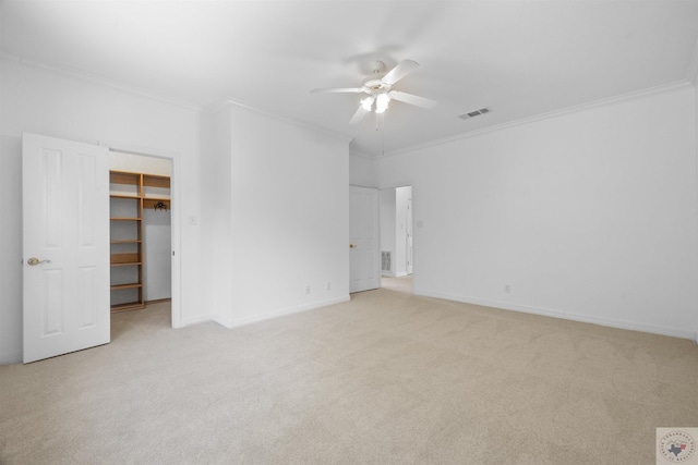 unfurnished bedroom featuring a closet, ceiling fan, a spacious closet, and ornamental molding