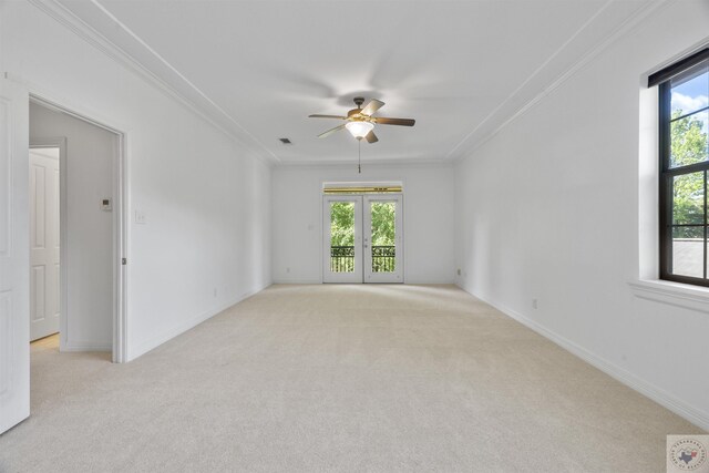 spare room featuring light carpet, ornamental molding, and plenty of natural light