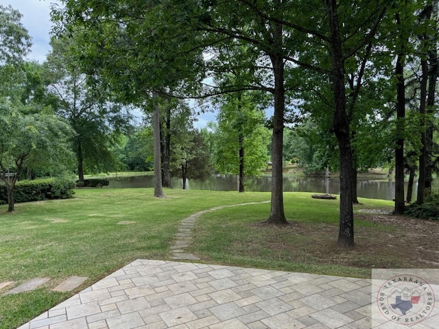 view of property's community featuring a lawn and a water view