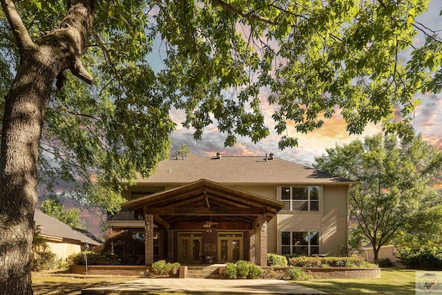 back of property at dusk featuring a ceiling fan and french doors