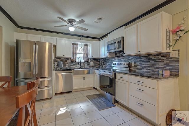 kitchen featuring white cabinetry, light tile patterned floors, appliances with stainless steel finishes, and a textured ceiling