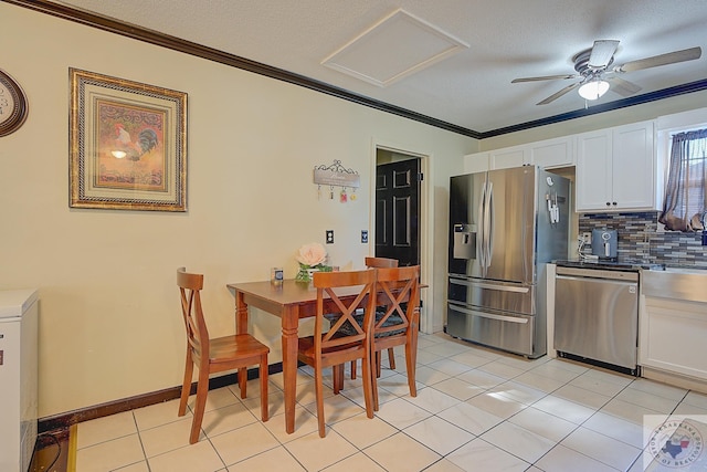 tiled dining room featuring ceiling fan, a textured ceiling, and crown molding