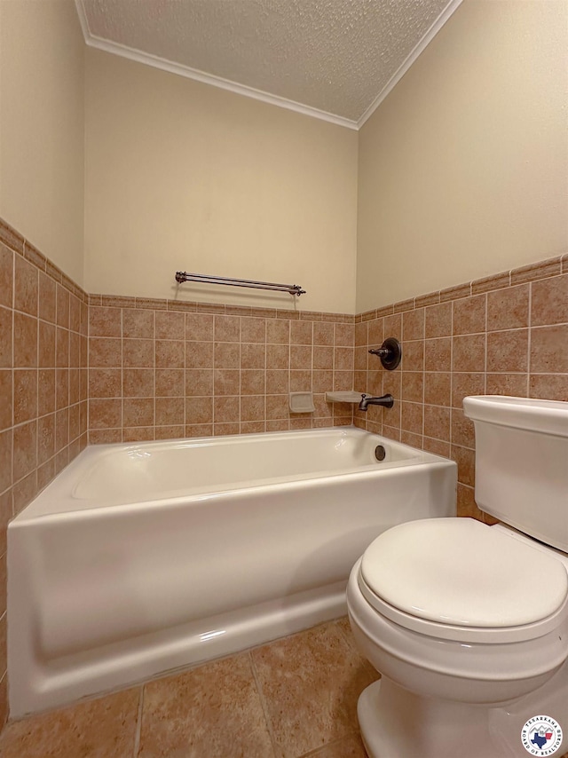 5082 Fm 44 W, Dekalb, TX 75559 - bathroom featuring toilet, crown molding, a bath, a textured ceiling, and tile walls