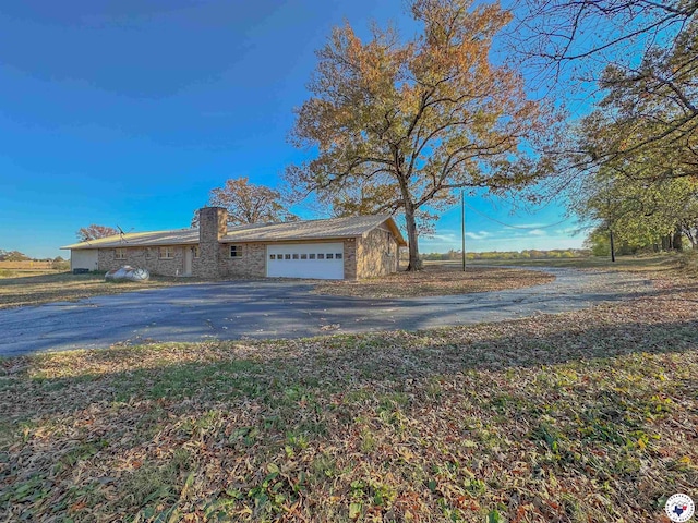5082 Fm 44 W, Dekalb, TX 75559 - view of front of property featuring asphalt driveway, a garage, and stone siding