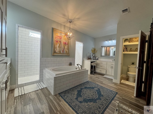 full bath with visible vents, a garden tub, toilet, a tile shower, and vanity