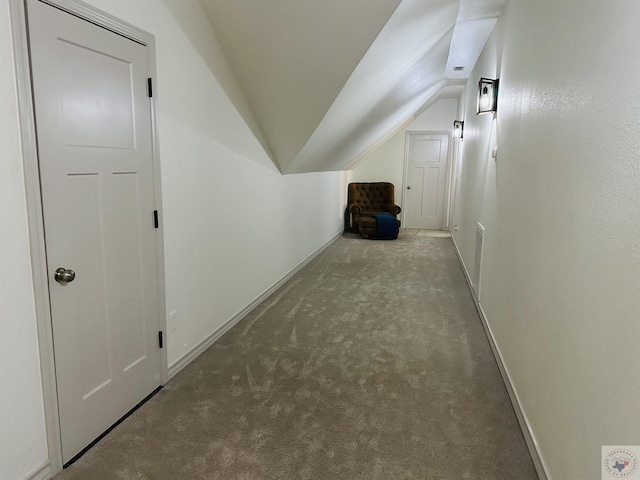 corridor featuring carpet flooring, baseboards, visible vents, and vaulted ceiling