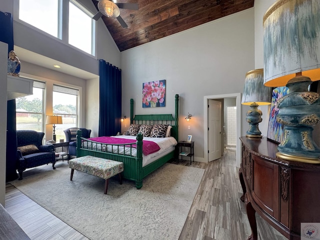 bedroom featuring high vaulted ceiling, multiple windows, wood ceiling, and wood finished floors