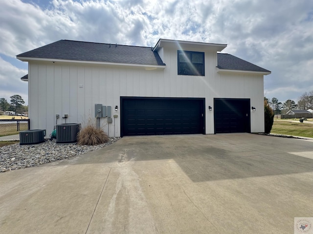 exterior space with an attached garage, a shingled roof, fence, central air condition unit, and driveway