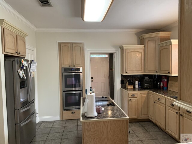 809 N Louise St, Atlanta, TX 75551 - kitchen with light brown cabinets, a kitchen island, visible vents, appliances with stainless steel finishes, and dark countertops