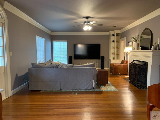 809 N Louise St, Atlanta, TX 75551 - living area featuring a fireplace with flush hearth, ornamental molding, wood finished floors, and a ceiling fan