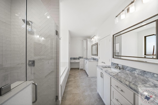 bathroom featuring a stall shower, two vanities, and a sink