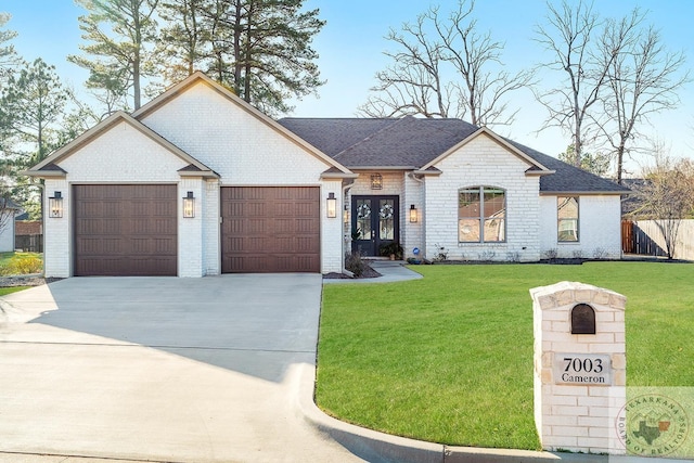 view of front of home with a front yard, brick siding, driveway, and an attached garage