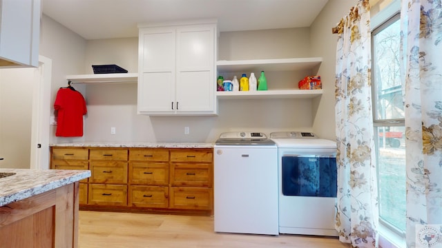 laundry room with light hardwood / wood-style floors and washing machine and dryer