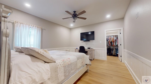 bedroom with a closet, ceiling fan, light hardwood / wood-style flooring, and a spacious closet