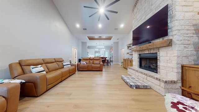 living room featuring light hardwood / wood-style flooring, a towering ceiling, and a large fireplace