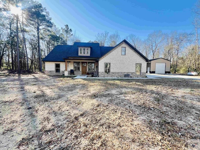 view of front of property featuring covered porch, an outbuilding, and a garage