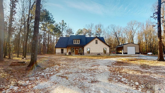 view of front facade with covered porch, an outdoor structure, and a garage