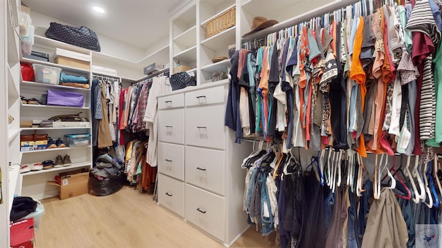 walk in closet with light hardwood / wood-style flooring